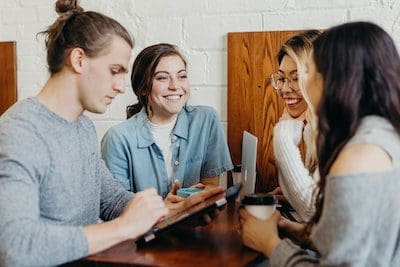 Social media helps you engage with your audience. A group of friends at a coffee shop.