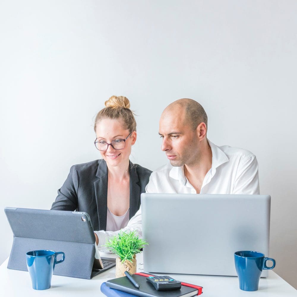 Mastering the Trio: How Small Businesses Shine in Google's 3-Pack through Proximity, Relevance, and Prominence. Two small business owners discussing local SEO strategies while examining website analytics on a laptop.