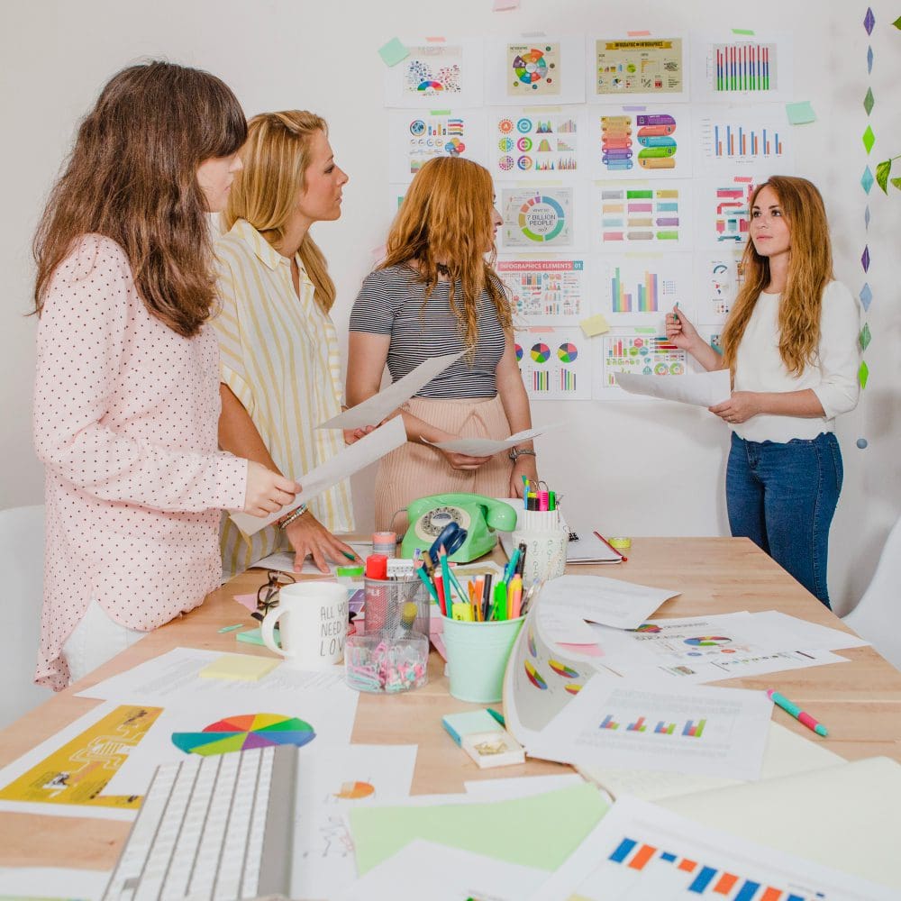 A group of local women discussing digital marketing strategies at a table. A group of local women discussing digital marketing strategies at a table.