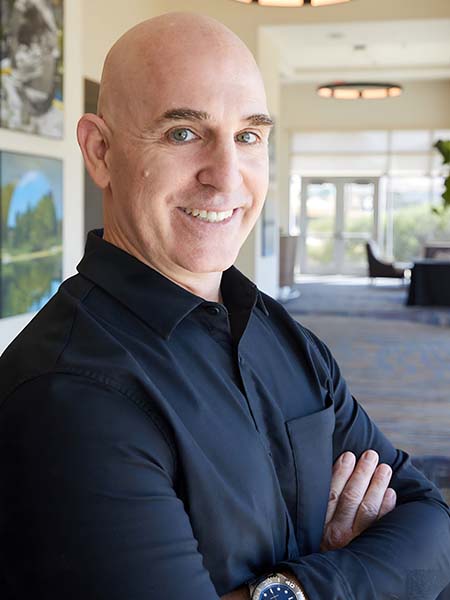 Brian Gibbs, a smiling bald man in a dark blue shirt, stands with his arms crossed in a well-lit, modern office hallway. Framed pictures adorn the walls, and large windows flood the space with natural light. Brian specializes in small business digital marketing and is a key player in digital marketing San Antonio. Brian Gibbs, a smiling bald man in a dark blue shirt, stands with his arms crossed in a well-lit, modern office hallway. Framed pictures adorn the walls, and large windows flood the space with natural light. Brian specializes in small business digital marketing and is a key player in digital marketing San Antonio.